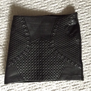  - Kort kjol i skinnimitation. Rak modell. Mittenbilden visar baksidan av kjolen, stängs med dragkedja. OBS tyget i bak är ej stretch! 

Köparen betalar frakt, kan annars hämtas i Göteborg. 