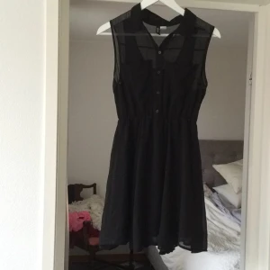 - Klänning från H&M. Superfint skick. Faller fint. Resår i midjan, knappar fram och bröstfickor.