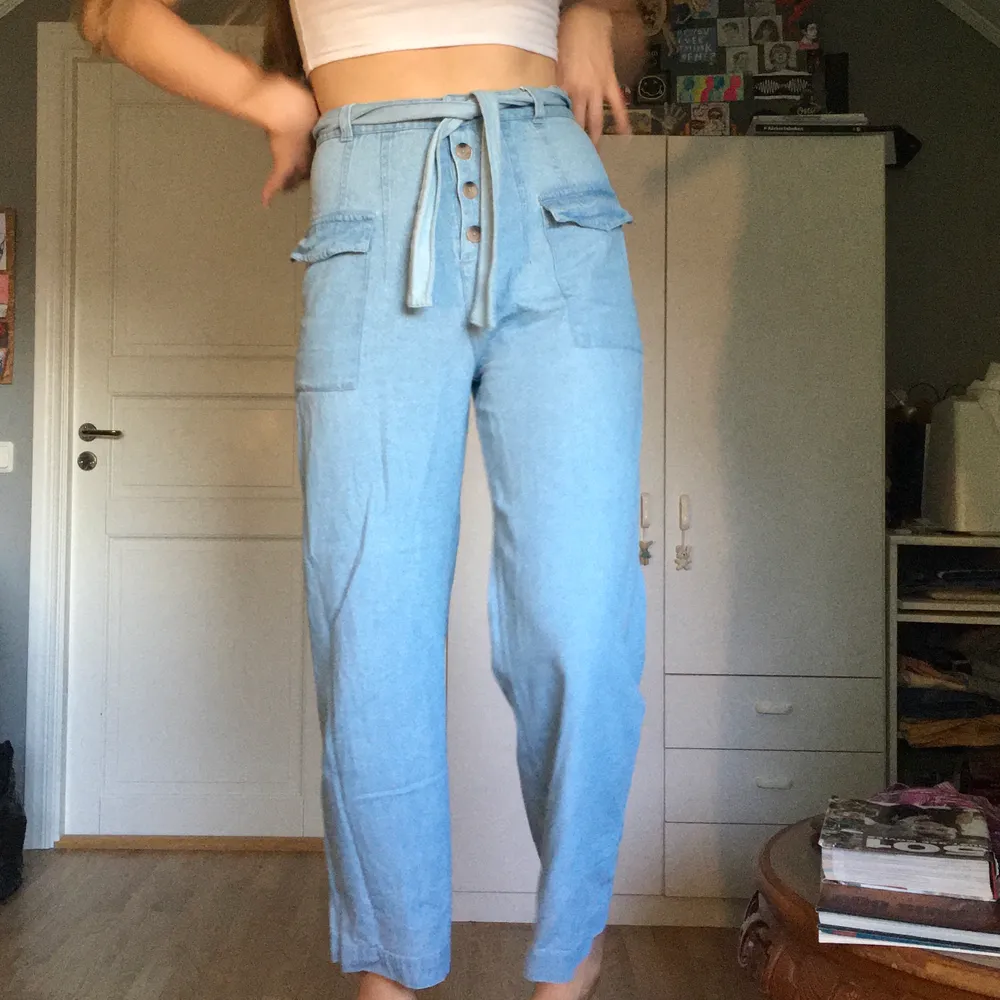 Ett par wide leg jeans i tunt tyg från asos med sidofickor och bälte. De är i storlek 38.. Jeans & Byxor.