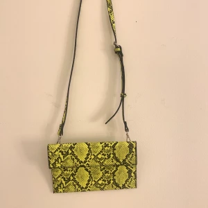 Väska - Säljer denna neon gröna väskan från zara, det ska vara någon grej på baksidan men den vär borta när jag köpte den, aldrig använd.
