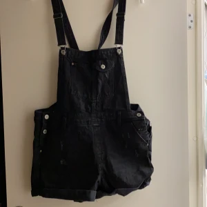 Hängselbyxor  - Svarta Hängselbyxor med slitningar. Använda 1 gång.