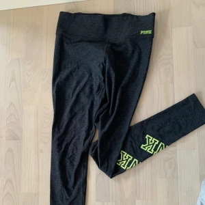 Träningstights Victoria Secret PINK - Mörkgrå träningstights från Victoria Secret, PINK. Lite tjockare tyg i midjan, dragkedja där bak.
