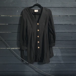 svart klänning storlek 34 - En finare svart lite mer figurklänning med knappar och knyten vid armar från asos. Använd 1 gång. Säljs pga för liten. 