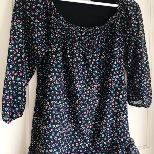 Mönstrad blus - Mönstras blus med trekvartslånga ärmar och volanger nedtill. Köpt i Frankrike. Knappt använd. Storlek S.