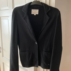 Kavaj från Bondelid  - Mörkblå kavaj med en knapp i mjukt material. Damstorlek L. Fin passform i fint skick. Om den ska skickas på posten tillkommer fraktkostnad. Betalas med Swish. 