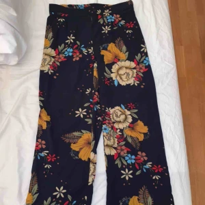  - Blommiga vida byxor. Byxorna slutar lite över ankeln på mig som är 171 cm. Väldigt sköna att ha en varm sommardag då dom är tunna och fladdriga! 🌸🌺🌼 köparen står för frakten