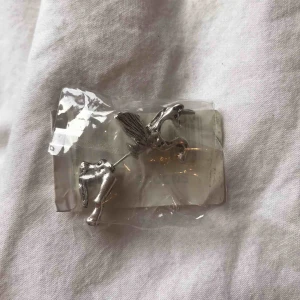  - örhänge i form av en enhörning där halva är på baksidan av örat.  aldrig använt. Frakt 11kr