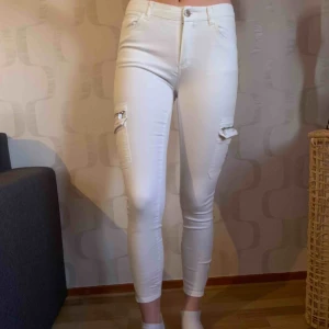  - Vita jeans med fickor på sidorna av benen. Aldrig använda.  Frakt kan tillkomma