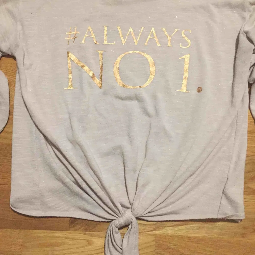 En Rosa halv genomskinlig tröja men texten #Always NO 1. Knyts längst ner. Toppar.