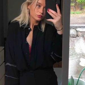  - Svart skjorta med detaljer. Lite ”oversize” modell, knappt använd. 