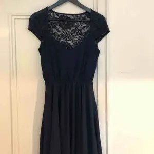 Mörkblå klänning med spets. Använd endast en gång på ett bröllop.