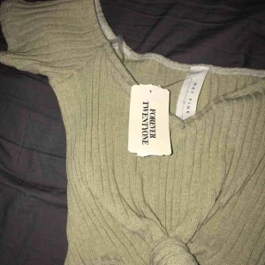  - En klänning från USA med knytning i mitten. Ser ut som en tröja och en kjol men allting sitter ihop :) Den är stretchig och ser liten ut men den formar sig efter kroppen.   Färg: Grön