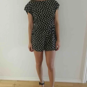  - Söt byxdress i tunt material som man knyter i ryggen.