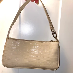 Beige handväska - En beigehandväska i jättefint skicka, knappt använd. Väskan var en present så vet inte riktigt vilket märke! 