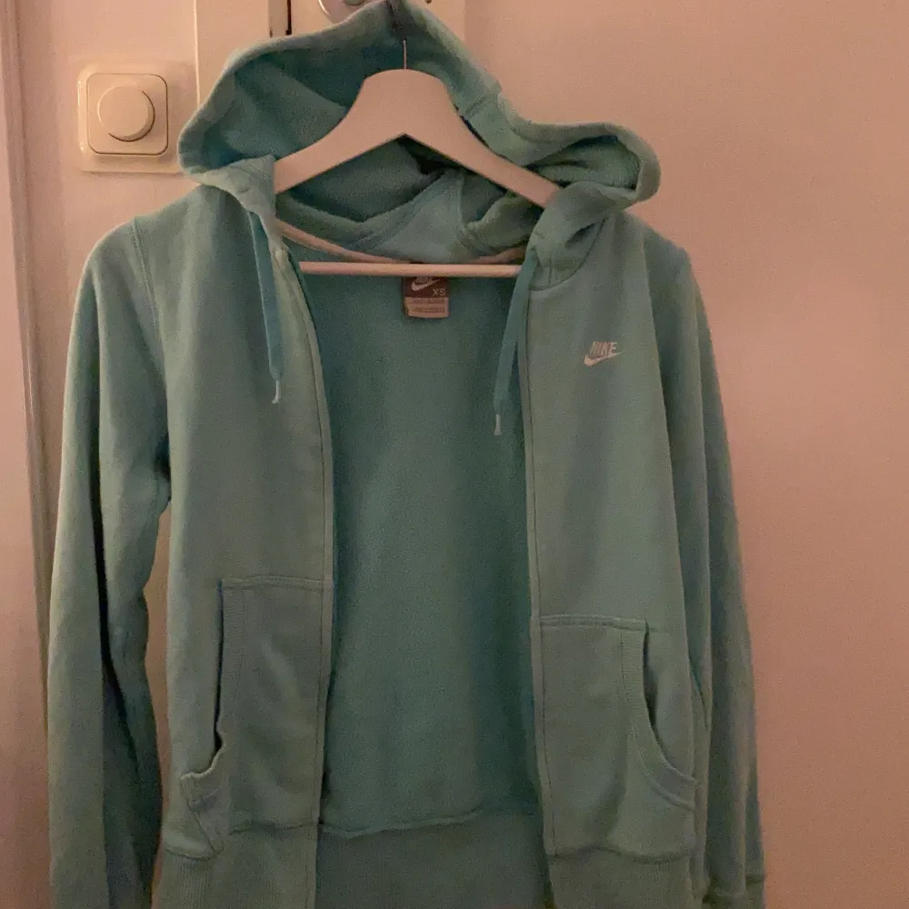 Jag säljer denna blåa Nike zipper hoodie eftersom den inte kommer till användning längre men den är i nästan nyskick, den är ÄKTA. Den är lite oversized och lång så passar mellan storlekarna xs-m. Om någon har några andra frågor hör bara av er!💞💞💞. Hoodies.