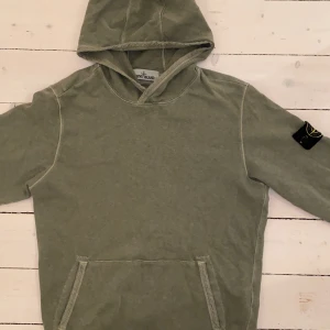 Stone Island - Säljer min gröna Stone Island Hoodie! Köpt i fin skidaffär kallad ”Strolz” i Lech. Har använt den ett par få gånger, den är i bra skick! Passar superbra på mig som är 1,77cm lång. Köpare står för frakt❗️