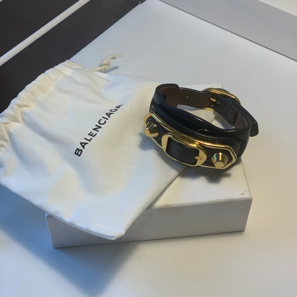 Ett mörkblått Balenciaga armband med gulddetaljer inköpt 2018 i Paris. Dustbag tillkommer vid köp. Armbandet är använt ett få tal gånger och är i mycket fint skick. Säljes för 600 kr.. Accessoarer.