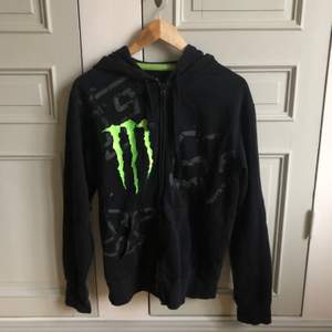 En svart monster-hoodie med dragkedja. Storlek medium 