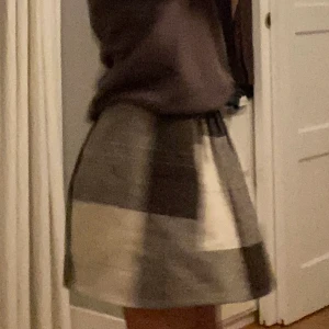 Rutig veckad kjol - En veckad kjol med svarta, gråa och vita rutor. Kjolen har 2 fickor och är köpt second hand. Jag är 165 och brukar bära storlek XS eller S och skulle säga att kjolen passar både storlekar. 