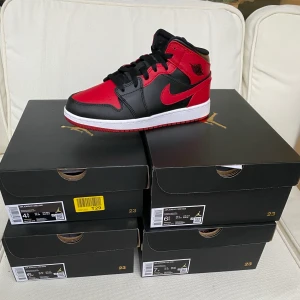 Nike Jordan 1 Banned Mid storlek 38,5-40 - Säljes ! Helt nya aldrig använda Jordan 1 mid banned med digitalt kvitto. Finns i storleken 40. Pris 1399kr. Hämtas i Stockholm Gröndal eller skickas på köparens bekostnad.