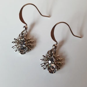 Örhängen spindlar - Silverfärgade örhängen med spindlar. Fraktkostnad blir 12kr.