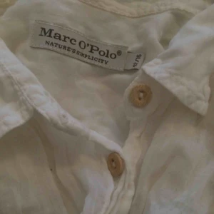  - Vit, tunn skjorta som passar mig (36) med loose fit. Halvgenomskinlig med knappar i trä. 