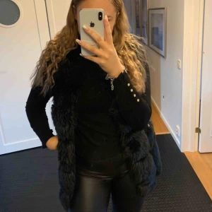 - Svart pälsväst. Passar mig som har storlek M i vanliga fall. Är ca 172 cm om man vill jämföra längden på västen. 