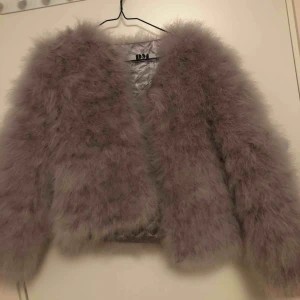  - Fluffig jacka med rosa toner. Endast använts en gång 