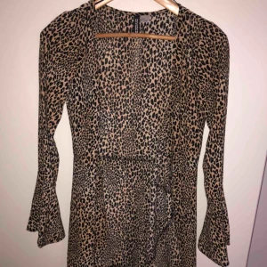  - Svårt att få en rättvis bild med den är som sista bilden fast med volanger i ärmarna! Omlottklänningen i leopardmönster. Aldrig använd pga liten storlek 