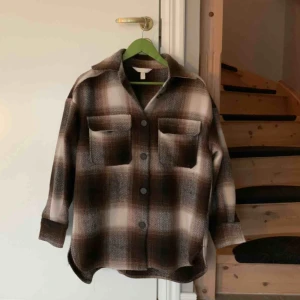  - Beige/brun rutig skjortjacka från hm. Storlek S/M men den är lite oversized. Använd ca. 4 gånger i höstas. Frakt ingår inte i priset:) Hör av dig om du undrar något 