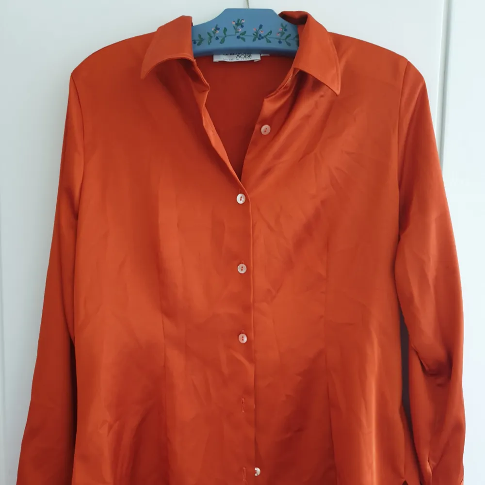 Skjorta i fantastisk orange färg. Lätt figursydd. Storleken är en Italiensk 46. Skjortor.