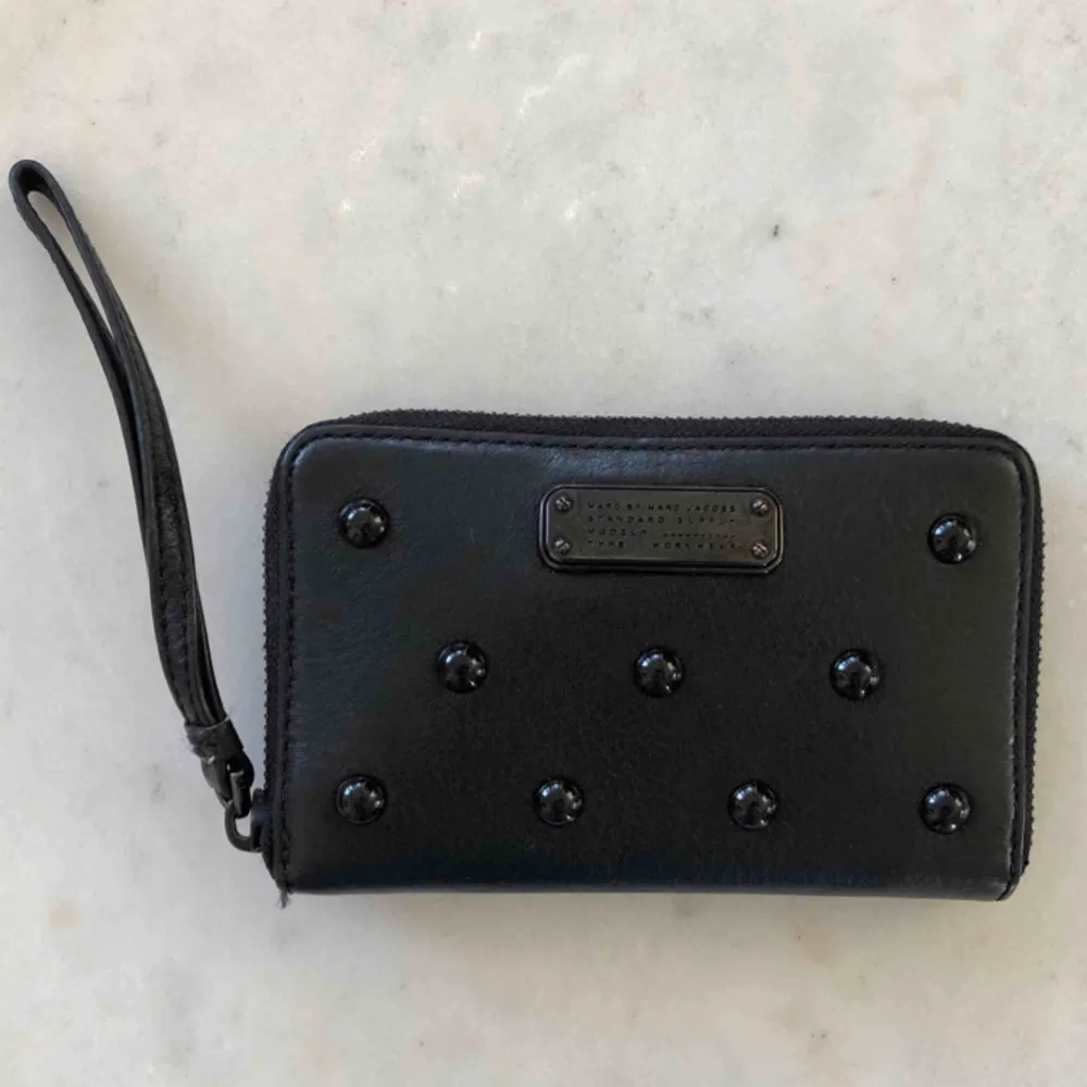 Marc by Marc Jabos black luna studded wallet - svart skinn med nitar på. Nypris 1880kr. Får plats med sedlar, mynt, mobilen och kort. Storlek 16x10 cm. Köparen står för fraktens bekostnad. Pris kan diskuteras, pm för fler bilder!  Cond. 9/10  <3. Accessoarer.