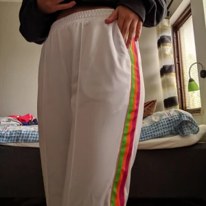  - Vita, snygga byxor med regnbågsmönster. Nya från junkyard, aldrig kommit till använding därav prislappen:))