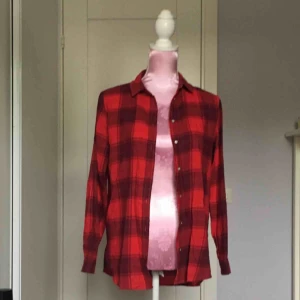  - röd flanellskjorta, stor i storleken beroende på hur man vill bära den 