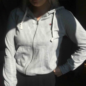  - En ljusgrå hoodie från champion. Använd ca 2 ggr så i väldigt fint skick. Frakt tillkommer på 59kr. Pris kan diskuteras vid snabb affär.🌸
