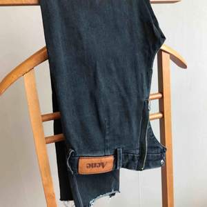Avklippta Jeans från Acne i storlek 26/32 Hål över knäna och dragkedja baktill