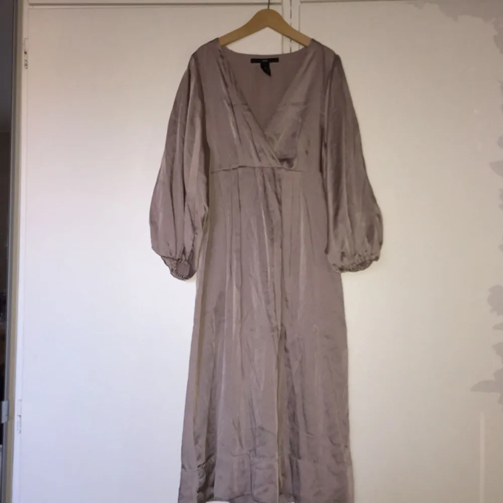 Fin klänning i silkestyg från H&M med halvlång ”puffärm”. Strl 34. Färgen är ljust gammelrosa. Klänningar.