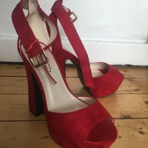  - Säljer dessa supersexiga röda klackar då de är lite förstora för mig! Har endast använt dem en gång och då stod jag mest bara still i dem. De är str 38 men skulle säga mer 39. Som man kan se på första bilden så har en ”flärp” gått av vilket det gjorde första gången jag skulle knäppa dem, flärpen är kvar i lådan och skickas med såklart, jag har löst det provisorist med lite ståltråd! Kan mötas upp i Malmö, annars så står köparen för frakt! :)