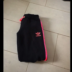  - Svarta adidas byxor med rosa streck  Storlek M men skulle säga att dom mer är som S  Pris kan diskuteras vid snabb affär  Köparen står för frakt om de skulle behövas 