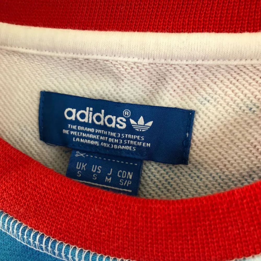 Tjocktröja från Adidas Originals med snyggt blått/rött print framtill. Använd fåtal gånger och i fint skick!  Leverans är inte inräknat i priset.. Tröjor & Koftor.