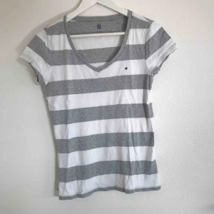  - Fin vit och grå randig, v-ringad t-shirt från Tommy Hilfiger. Sällan använd men inte min stil. Strl M men passar lika väl en XS/S. Eventuell frakt står köpare för 💗⚡️