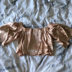  - Supersnygg croppad champagnefärgad offshoulder tröja i silke från Bershka. Storlek S