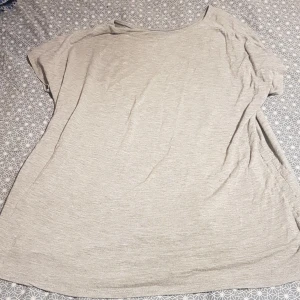 En grå slapp t-shirt. - De här en grå mycket slapp t-shirt. Köparen betalar frakt.