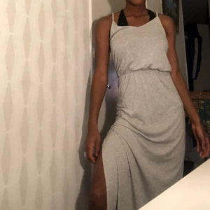 Grå lång klänning med slits - Gullig till sommarn, lång till fötterna! På bilderna kan man se tydligt vart slitsen börjar för har dragit upp klänning lite! Frakt tillkommer 💕