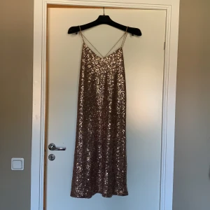 Zara dress size M - The dress has never been worn before. It is in good condition. However one stripe has the golden material not properly wraped around it. This is not notiecable. The dress is until knees and has open slit on the sides. 