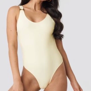 Baddräkt st. XS - Säljer denna fina baddräkt för den va förliten för mig men baddräkten är från NA-KD och helt oanvänd. Den är ljusgul och har en djup rygg samt din detalj vid axlarna😊 (första bilden lånad)