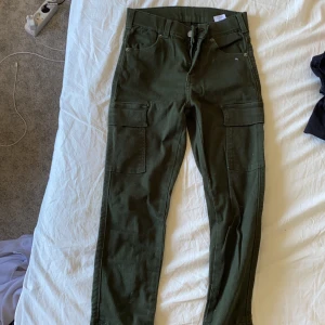 Coola byxor från Drdenim  - Militärgröna Cilla byxor med fickor och dragkedja bered vid fötterna. Vet inte vad de ör för storlek men tror de är xs-s. Först till kvarn du betalar frakt. 