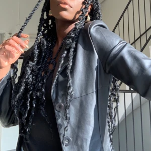 Skinnkappa - Skön till vår/sommar då den är ofodrad. Två dolda fickor på sidorna. Kappan har ett fint fall och är snygg både till vardags men även om man vill klä upp sig. 