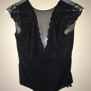 Svart body spets/mesh - Kortärmad body i spets/mesh, går ner i ryggen. Använd fåtal gånger, bra skick