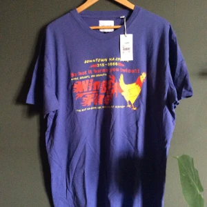 Valient grafic T-shirt - Aldrig använd och prislappen sitter fortfarande kvar. Köpte den impulsivt och har aldrig fått användning för den. Färgen är åt det blå-Violeta hållet med röd och gult tryck.